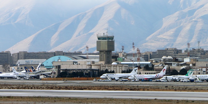 An airport control tower at Mehrabad with a runway, parked airplanes of IranAir and ground traffic.