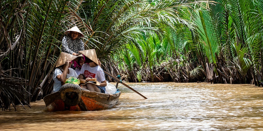 An image of the Mekong River in Vietnam with boats, lush greenery, and a serene waterscape.