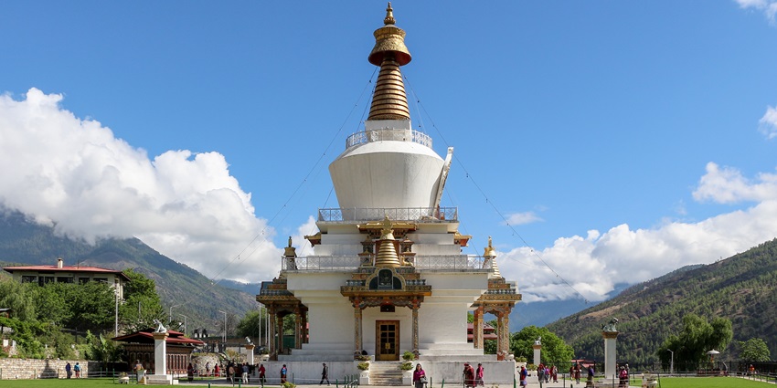 The white Memorial Chorten in Thimphu, with golden spires and prayer flags fluttering around it.