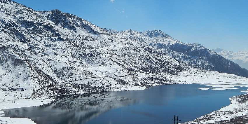 Menmecho Lake with a small water body surrounded by white snow shorelines and mountains