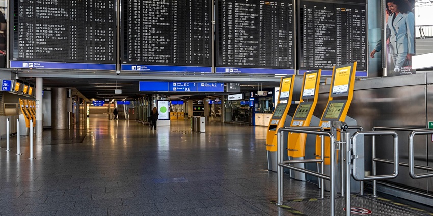 Inside an airport with vast LCD Screens lined in a row showing arrivals and departures