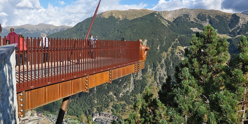 An image of a breathtaking viewpoint with a glass platform extending over the mountains.