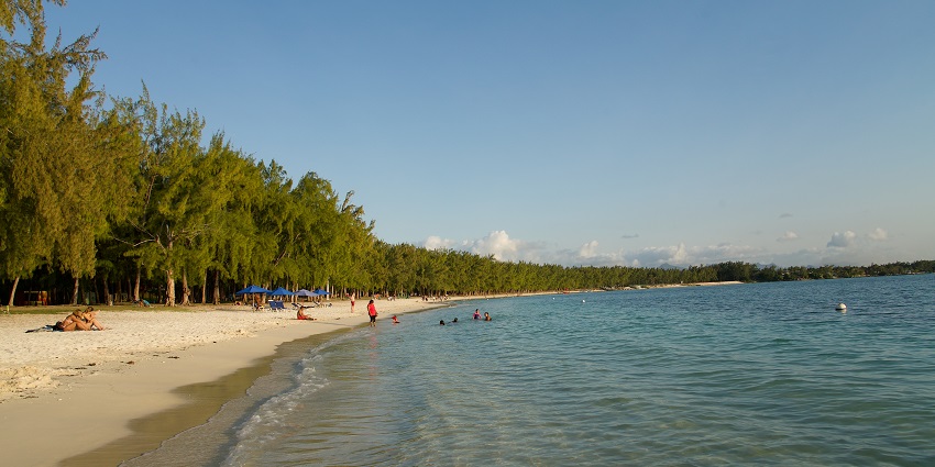 Image of Mont Choisy Beach, showcasing golden sands, turquoise waters, and visitors enjoying the shore.