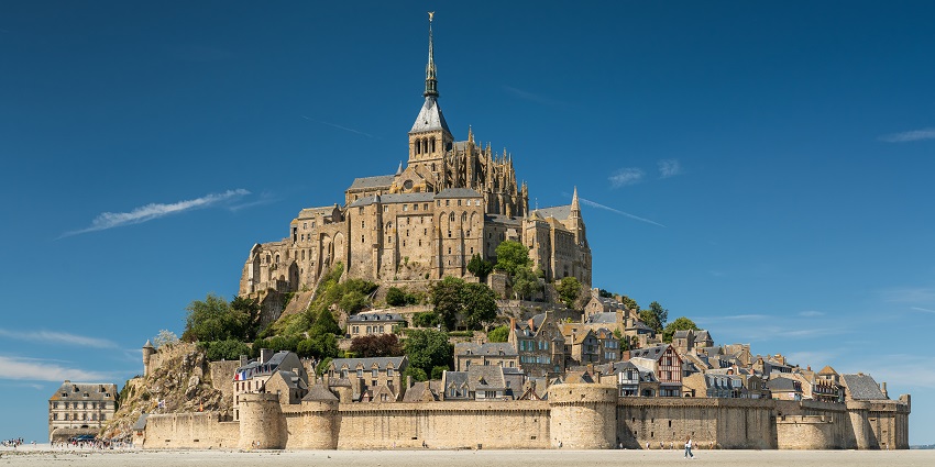 Mont Saint-Michel bathed in afternoon light, rising majestically above the tidal waters