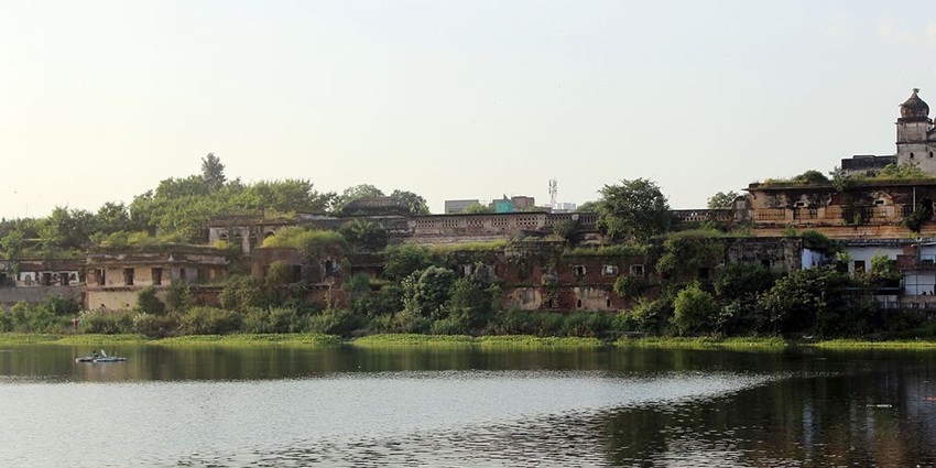Motia Talab, a famous lake in Bhopal, reflecting the greenery, a boat and old buildings