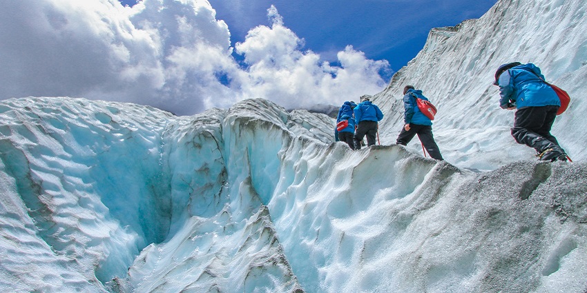 Three trekkers climbing snow-peaked Mount Everest, for a thrilling experience