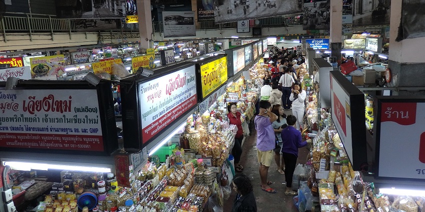 Bustling Mueang Mai Market in Chiang Mai, filled with fresh ingredients, street food, and Thai iced coffee.