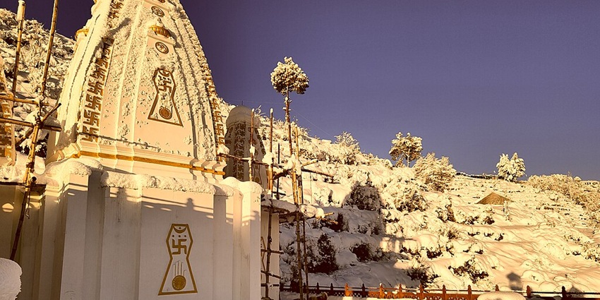 View of Mukteshwar Temple, with sunrise hues reflecting on the snow