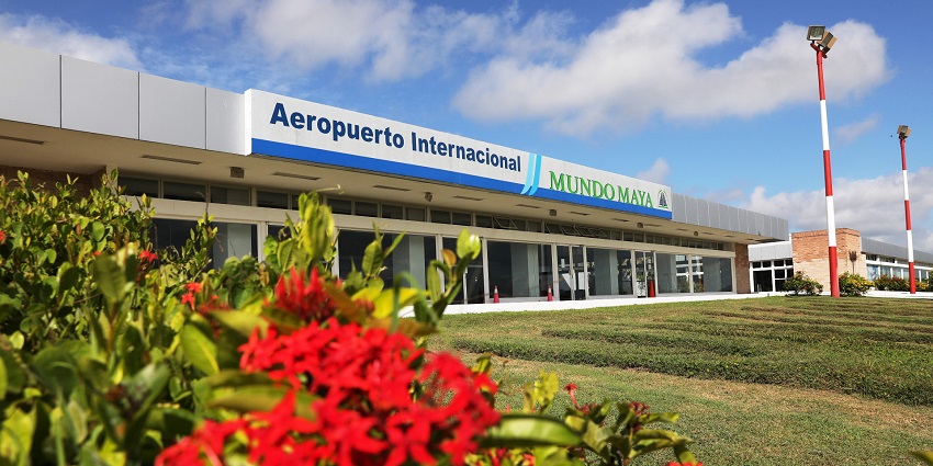 Terminal of Aeropuerto International Mundo Maya with a red flower plant in the foreground.
