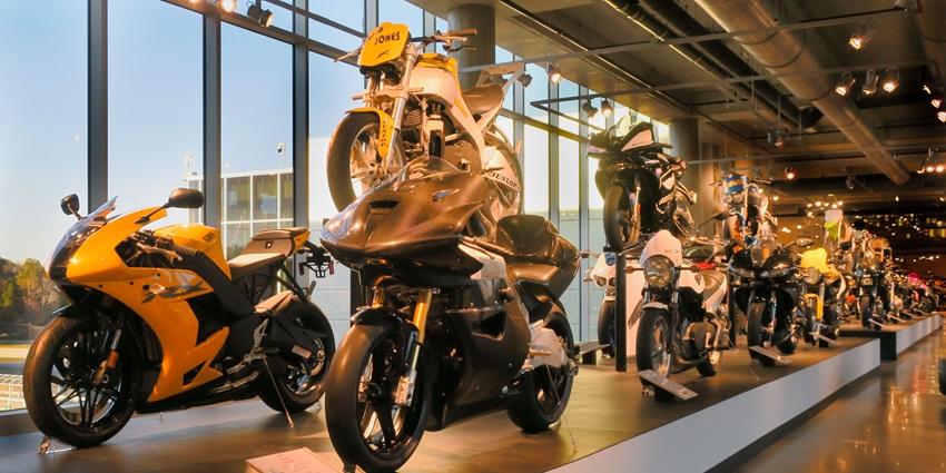 A museum showcases vintage motorcycles in different colours and exhibits in rows
