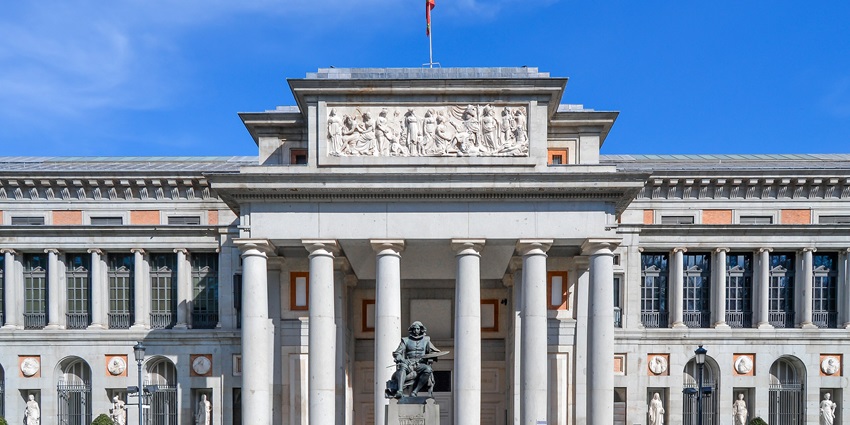 A majestic frontside view of Museo del Prado under a clear bluish sky in Madrid