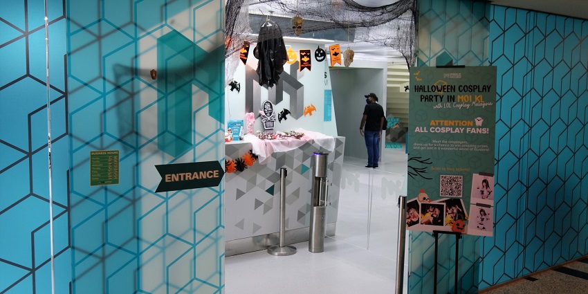 An image of a Halloween-themed entrance with decorations and blue geometric walls in Kuala Lumpur.