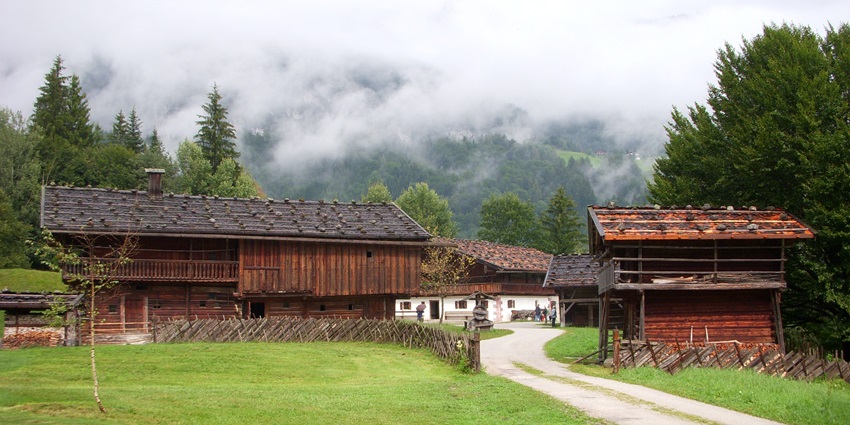 A paved pathway between two historical buildings surrounded by hills in this top museum.