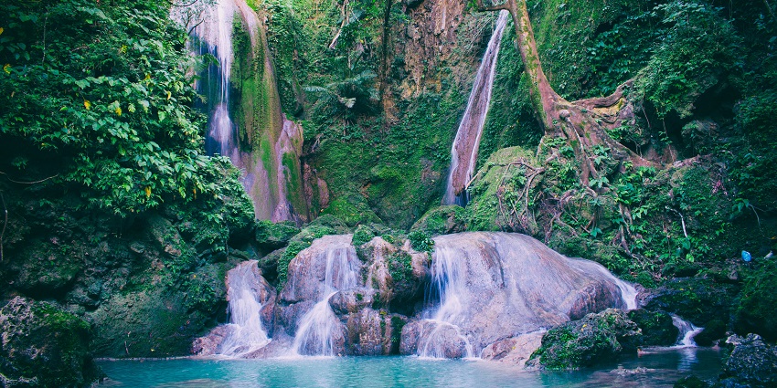 An image of a waterfall cascading into a blue pool, similar to Sutherland Falls New Zealand.