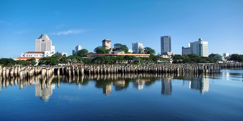 An image of a foggy forested area with tall trees and distant buildings in Johor Bahru.