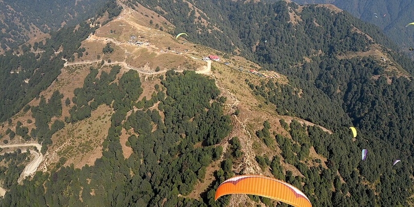 An image of a paraglider soaring over Bir-Billing's hills, capturing the essence of adventure and serenity.