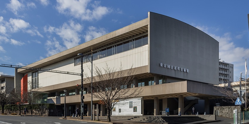 Exterior view of the National Museum of Modern Art in Tokyo during the day, showing its minimalist facade and modern design under a clear sky.