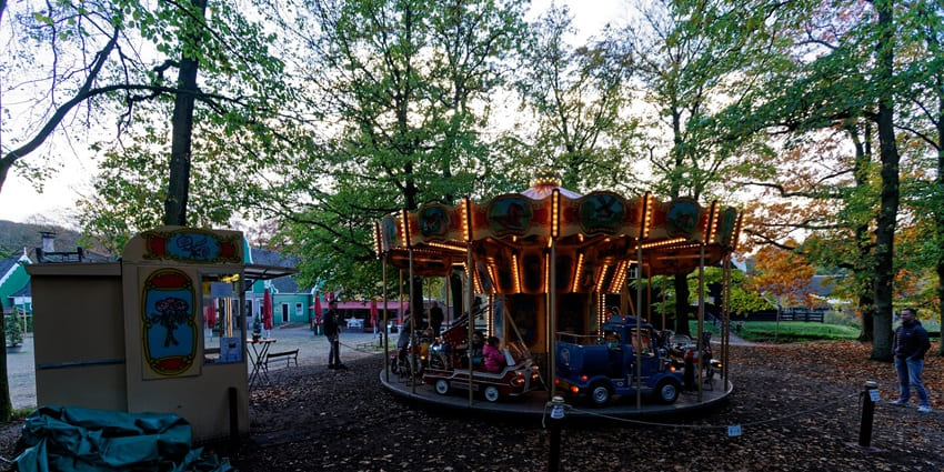 A few kids enjoying a toy car ride on the premises of the Netherlands Open Air Museum.