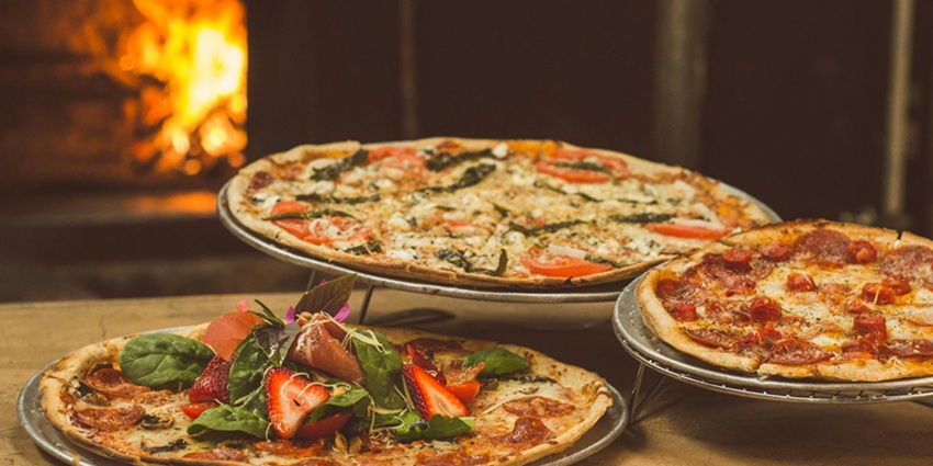 An image of a thin slice of New York-style pizza, one of the best foods in the USA.