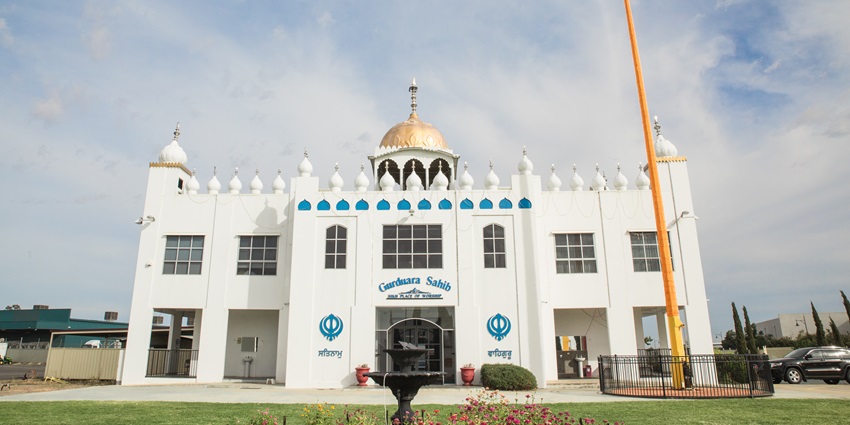 Gurudwara sahib with a white architectural building of gurudwara and a golden dome on top