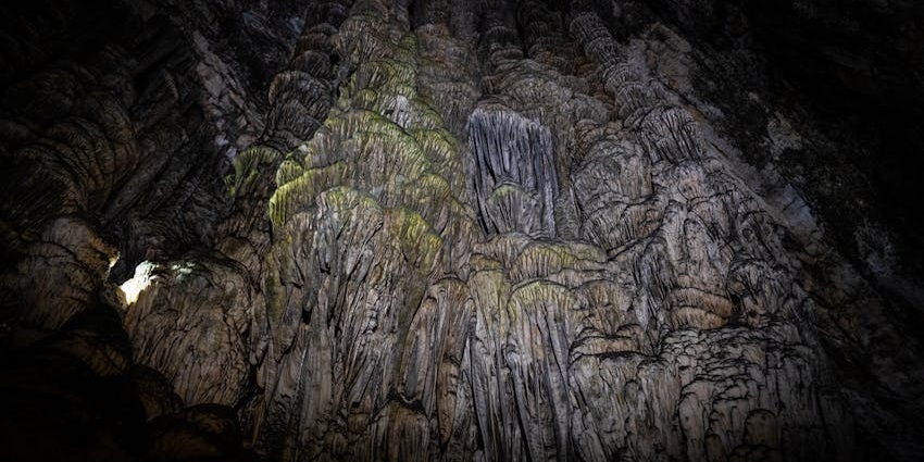 Cave with stalactites, detailed rock formations, showcasing the beauty of a natural cave.