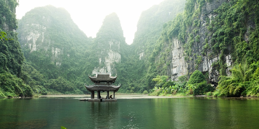 A mesmerising view of Tràng An featuring tranquil waters and lush greenery.