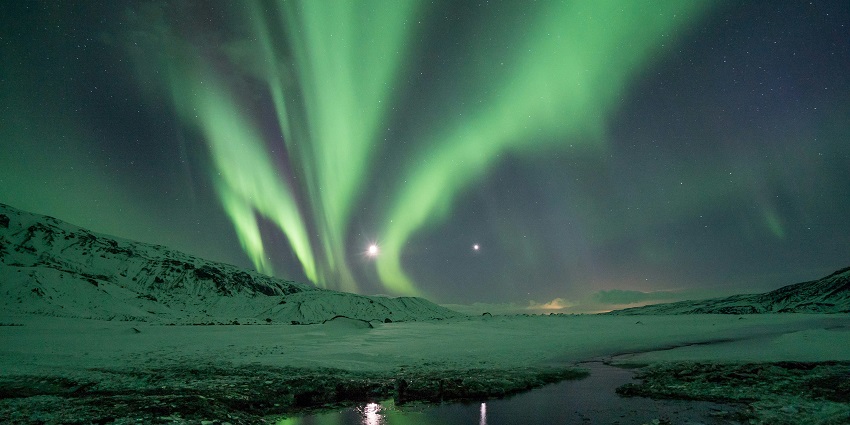 Witness the magical Northern Lights in Iceland as dazzling green, purple, and blue auroras