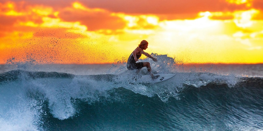 Image of a Man Surfing on Waves with picturesque views at the beach clear water