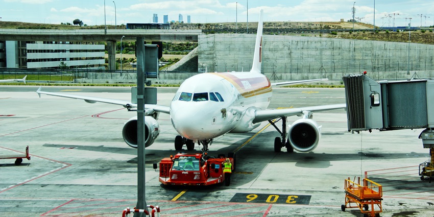 A commercial aircraft is approaching the runway, moving steadily toward the airport gate.