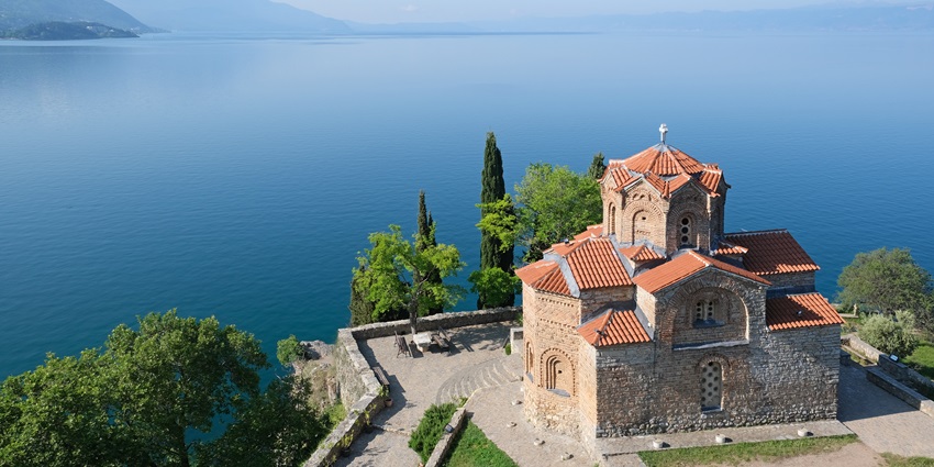 An image of Ohrid Lake, one of the top places to visit in North Macedonia, with the Church of St. John at Kaneo perched on a cliff.