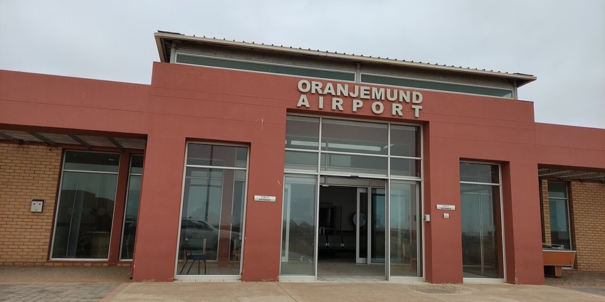 Oranjemund Airport’s terminal painted red with glass doors and small plates on the wall