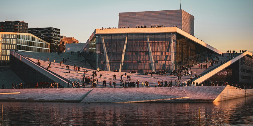 Oslo waterfront with modern architecture, Oslo Opera House, and serene fjord views.