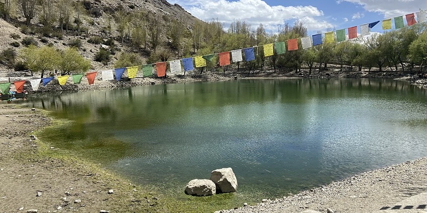 Nako Lake with a bright green water body, rocky mountains surrounded by green trees
