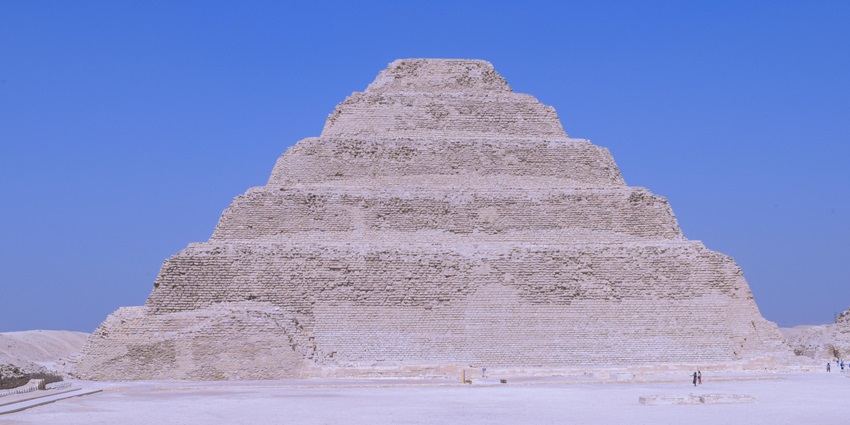 An image of the pyramid, surrounded by ancient ruins and desert sands.