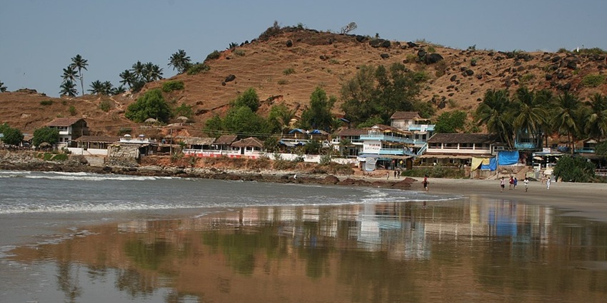 An image of mountains on Arambol Beach, surrounded by golden sand under the bright sun
