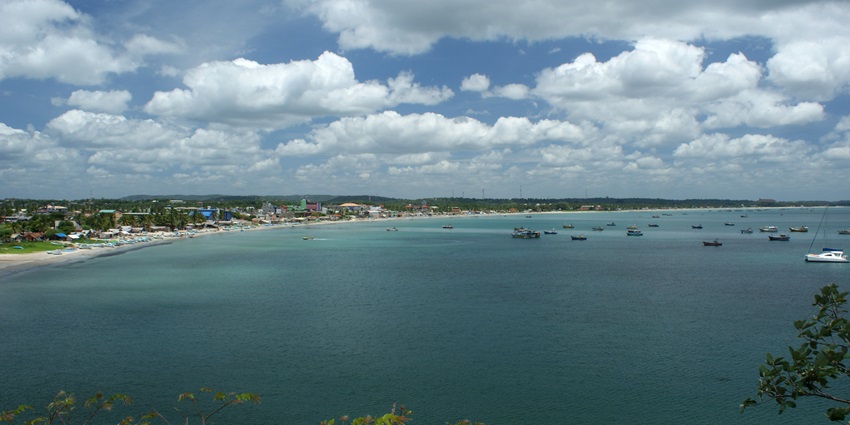 An image showing a bay in Trincomalee with azure waters during the daytime.