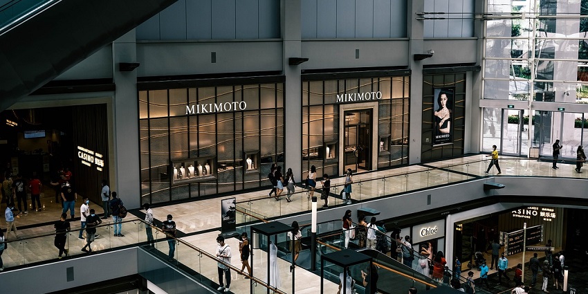 An image showing the inside of a shopping mall in a busy urban area.