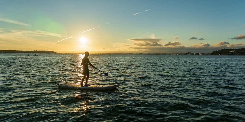 Image resembling a paddle boarder in Nusa Dua, one of the best water sports in Indonesia.