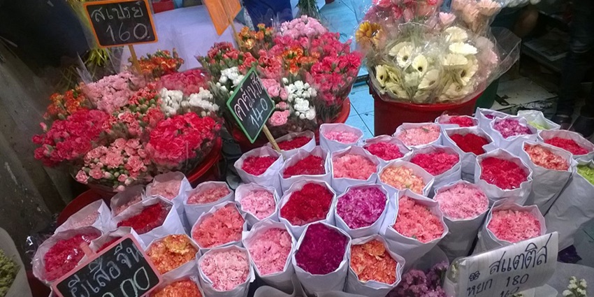 Bustling Pak Khlong Talat flower market in Bangkok, offering diverse flowers near Wat Pho Temple.