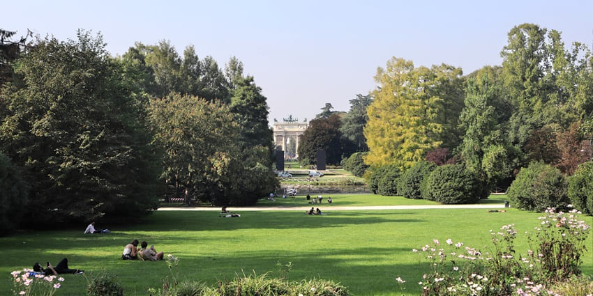 People relax at the lush green gardens of Parco Sempione as seen from the Sforza Castle, one of the places to visit in Milan.