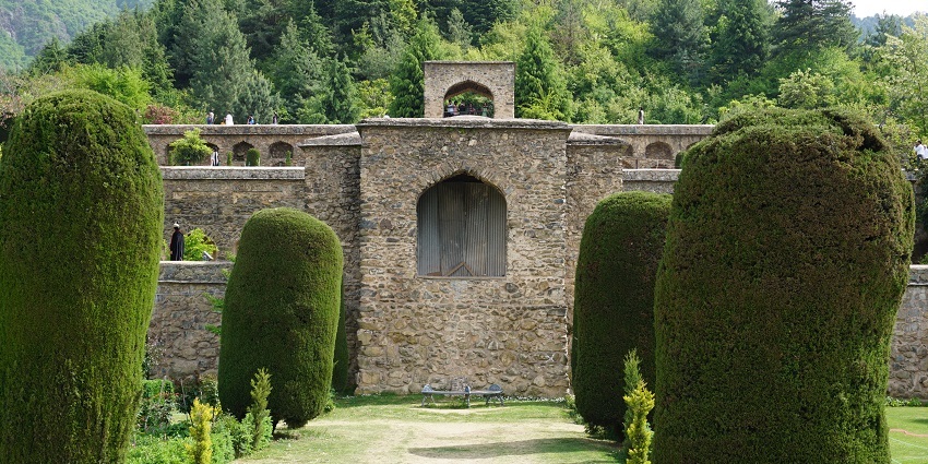 Pari mahal with a traditional architecture, finely cut trees, and surrounded by greenery