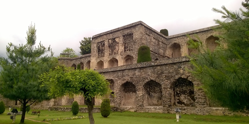Pari Mahal with traditional architecture, finely cut trees in a green garden and night lights