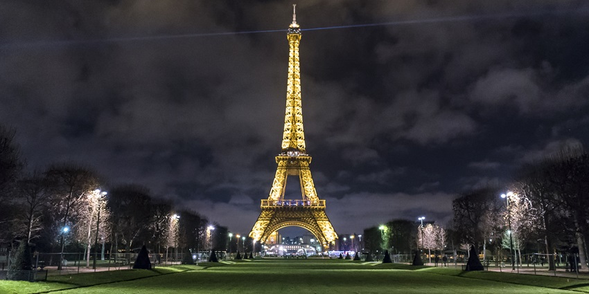 An image showing the Eiffel Tower in Paris, France, illuminated against the night sky