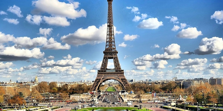 A breathtaking view of the Eiffel Tower framed by vibrant autumn leaves in Paris, France.