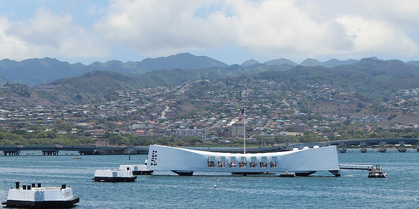 An image showing the USS Arizona Memorial at Pearl Harbor, Oahu, Hawaii, in serene waters.