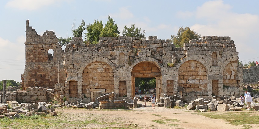 A picture of the iconic collonaded street in Perge Ancient City, surrounded by historic ruins.