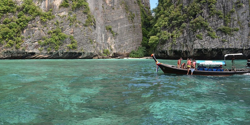 An image showing Phi Phi Islands,with boats and limestone cliffs