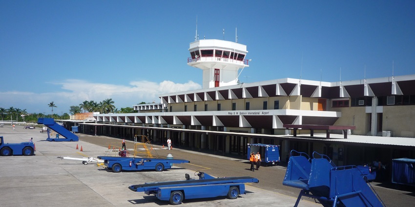 Philip S. W. Goldson International Airport with modern buildings and passenger stairs