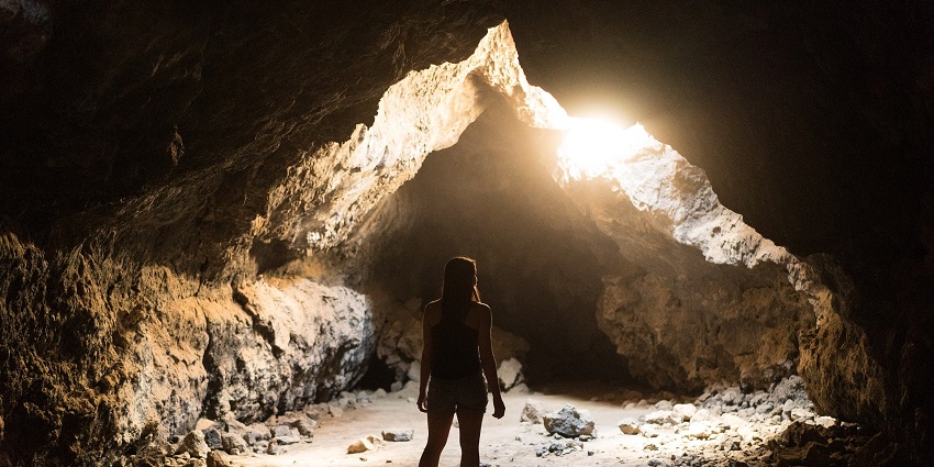 An image of a person exploring a cave similar to Phnom Chhngok Cave, a travel site.