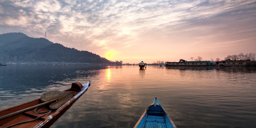A tourist capturing the stunning winter landscape of Dal Lake in December
